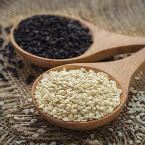 White sesame and black sesame seed on wooden spoon